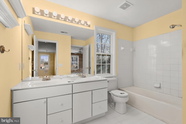 full bathroom with vanity, tile patterned flooring, tiled shower / bath combo, and toilet