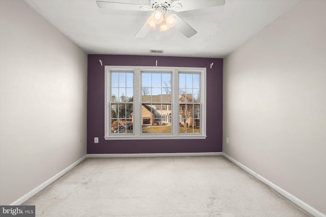 spare room featuring ceiling fan and carpet