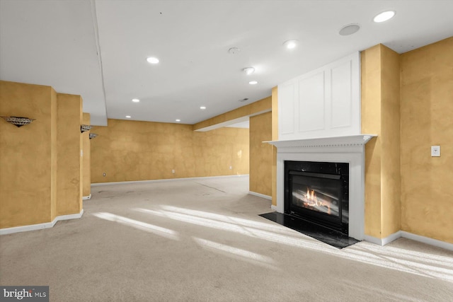 unfurnished living room featuring light carpet and a large fireplace