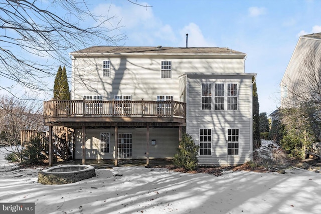 snow covered property with a deck and a fire pit