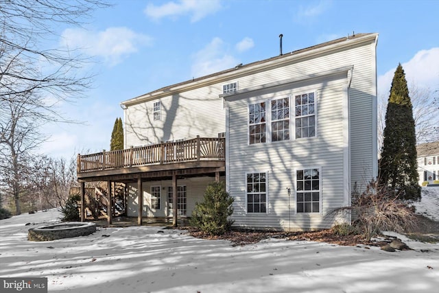 snow covered house featuring a deck