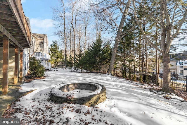 yard layered in snow featuring an outdoor fire pit