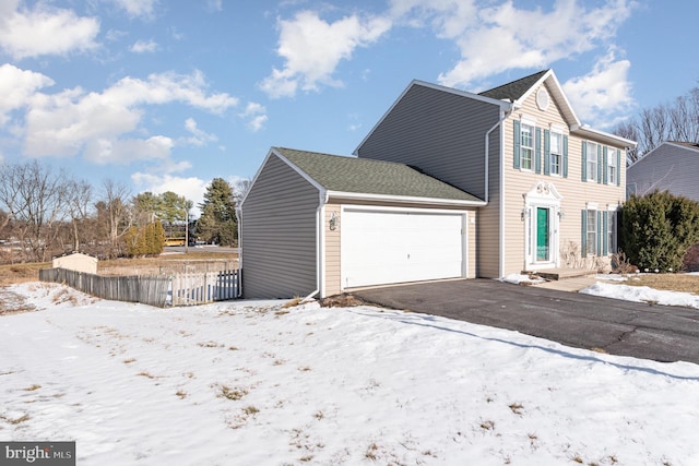 view of snowy exterior featuring a garage