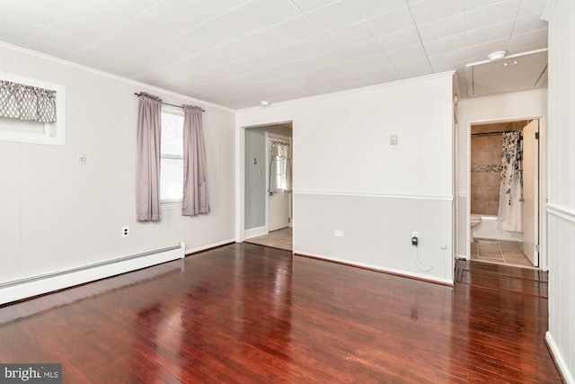 spare room with dark wood-type flooring, ornamental molding, and baseboard heating