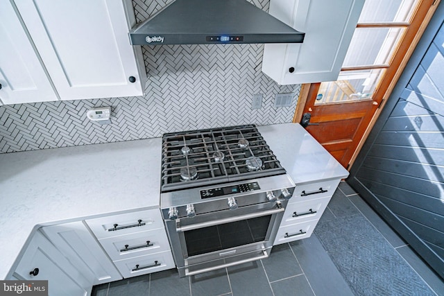 kitchen with white cabinetry, wall chimney exhaust hood, and dark tile patterned flooring