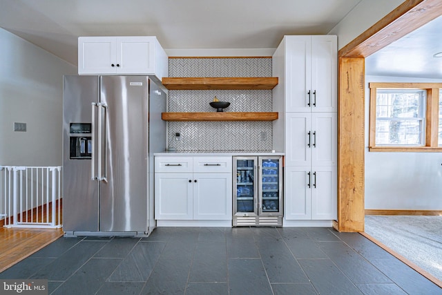 kitchen with white cabinetry, decorative backsplash, high end refrigerator, and beverage cooler