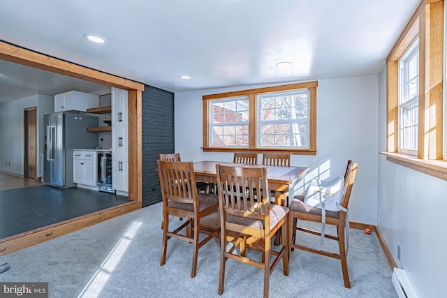 dining space with wine cooler, light carpet, and a baseboard heating unit