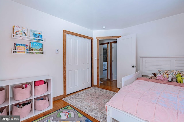 bedroom with light hardwood / wood-style floors and a closet