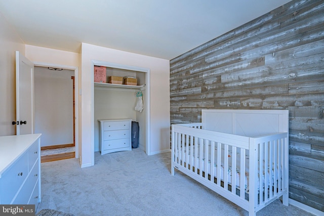 unfurnished bedroom featuring light colored carpet, a closet, and a nursery area