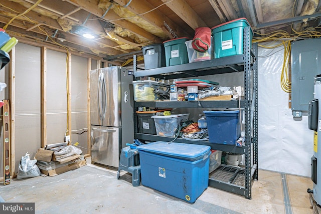 basement featuring electric panel and stainless steel refrigerator