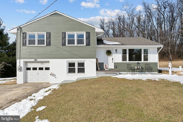 tri-level home featuring a garage and a front yard