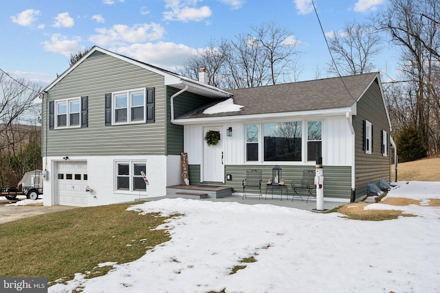 tri-level home with a garage and a lawn