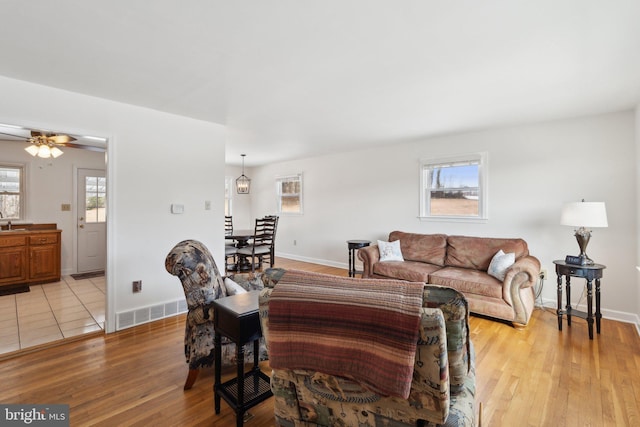 living room featuring ceiling fan, a healthy amount of sunlight, and light hardwood / wood-style flooring