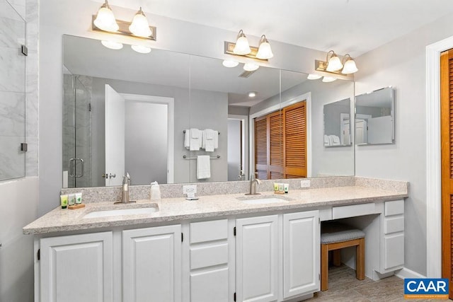 bathroom with vanity and a shower with door