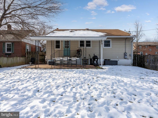 snow covered house with a deck