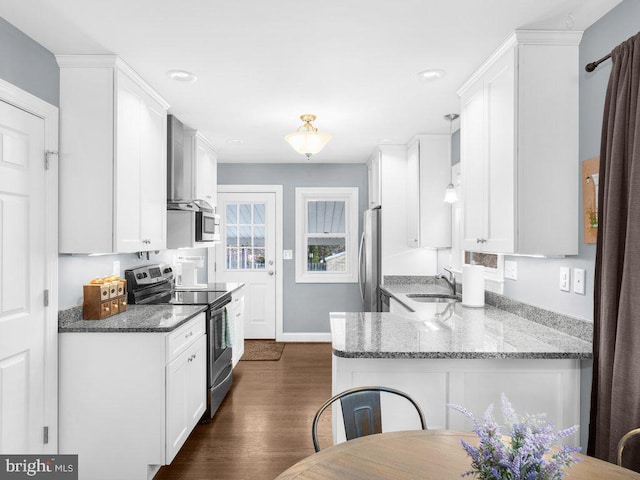 kitchen featuring sink, stainless steel appliances, dark stone counters, and white cabinets