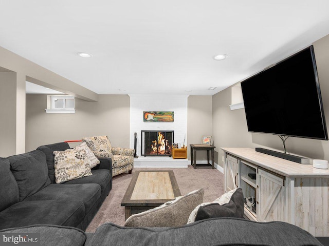 living room featuring carpet and a large fireplace