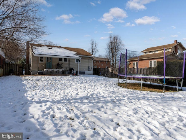 snow covered house featuring a trampoline