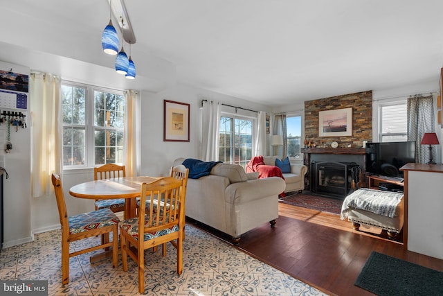 dining room featuring hardwood / wood-style flooring, a wealth of natural light, and a fireplace