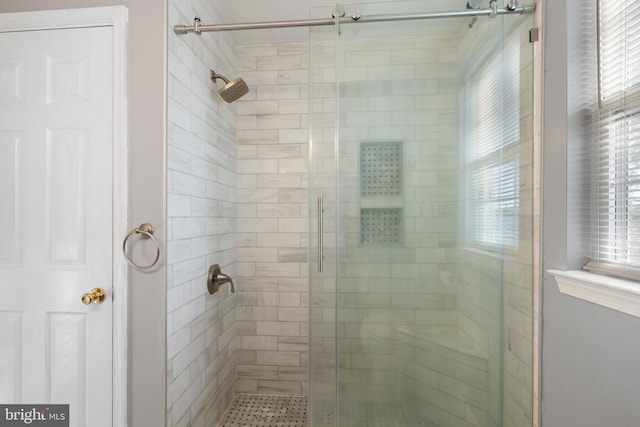 bathroom with an enclosed shower and plenty of natural light