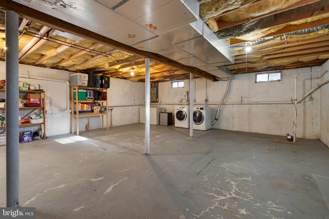 basement with electric panel and washing machine and clothes dryer