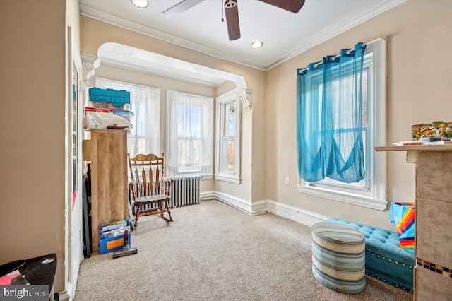 sitting room with ornamental molding, carpet flooring, radiator, and a healthy amount of sunlight