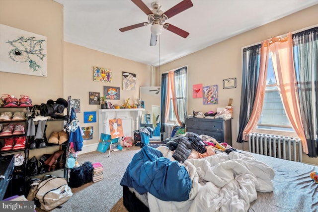 carpeted bedroom with radiator heating unit and ceiling fan