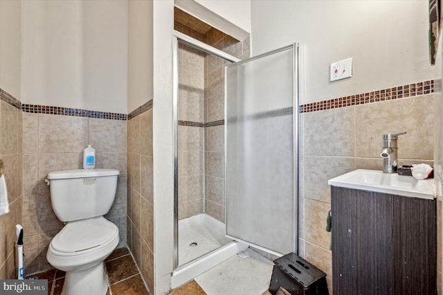 bathroom with walk in shower, vanity, toilet, and tile walls