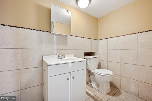 bathroom featuring vanity, tile walls, tile patterned floors, and toilet