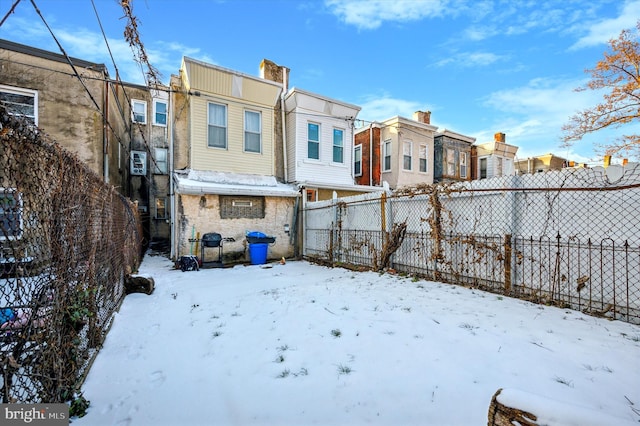 view of snow covered back of property