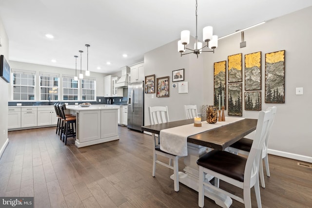 dining space with dark hardwood / wood-style floors and a chandelier