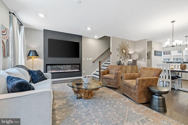 living room with hardwood / wood-style flooring, a healthy amount of sunlight, and an inviting chandelier