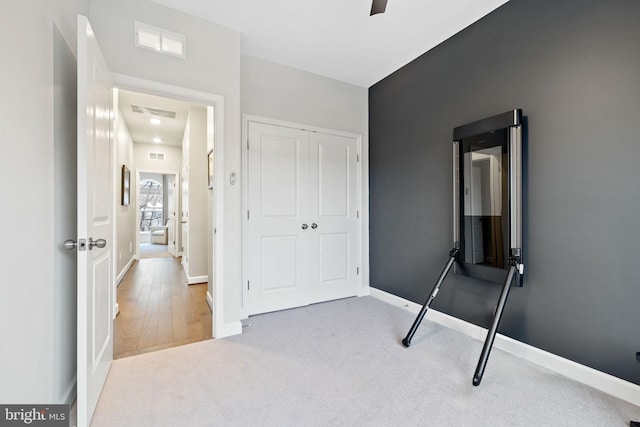 unfurnished bedroom featuring light carpet, ceiling fan, and a closet