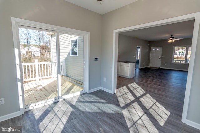 interior space with ceiling fan, dark wood-style floors, and baseboards