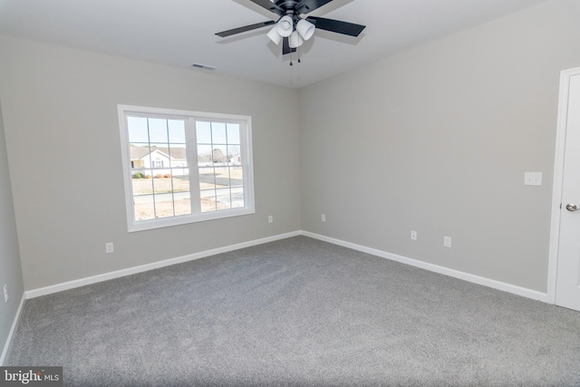 carpeted empty room featuring baseboards, visible vents, and ceiling fan