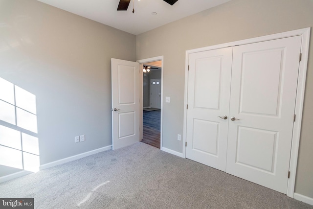 unfurnished bedroom with carpet floors, a closet, ceiling fan, and baseboards