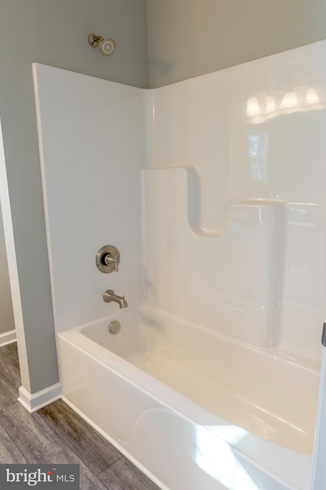 full bathroom featuring shower / bathtub combination, wood finished floors, and baseboards