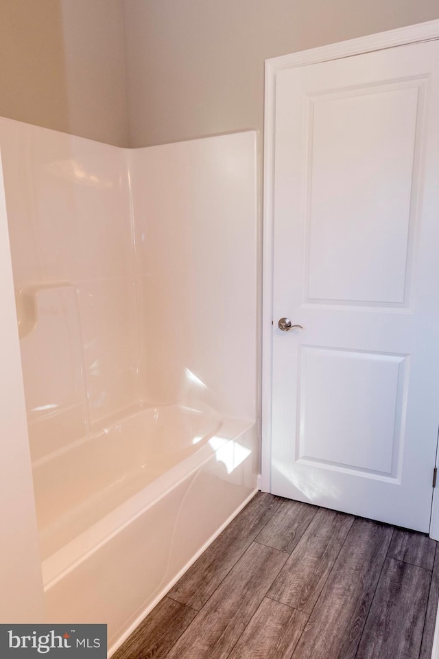 bathroom with a washtub and wood finished floors