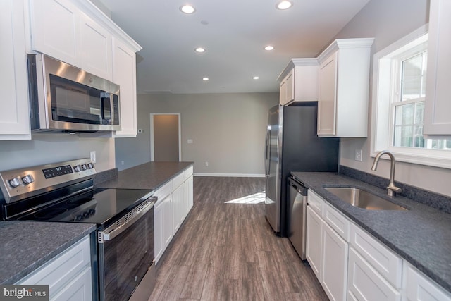 kitchen with stainless steel appliances, a sink, white cabinetry, and recessed lighting