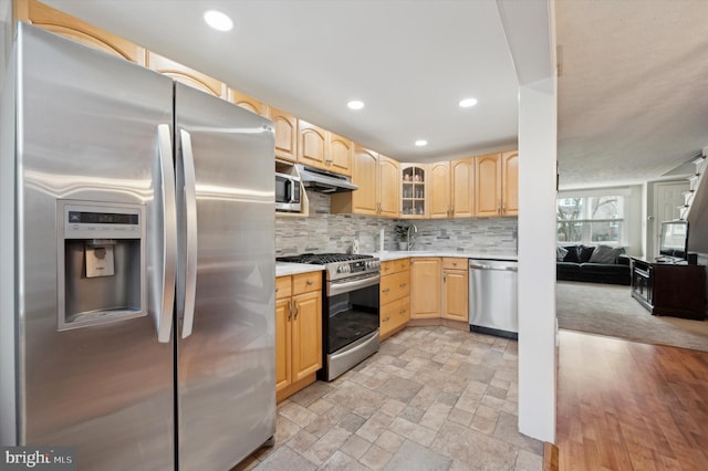 kitchen with tasteful backsplash, appliances with stainless steel finishes, and light brown cabinets