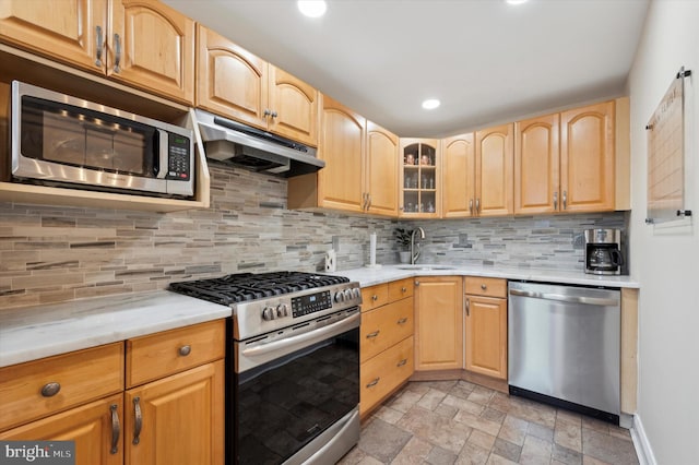 kitchen featuring sink, tasteful backsplash, light stone counters, light brown cabinets, and stainless steel appliances