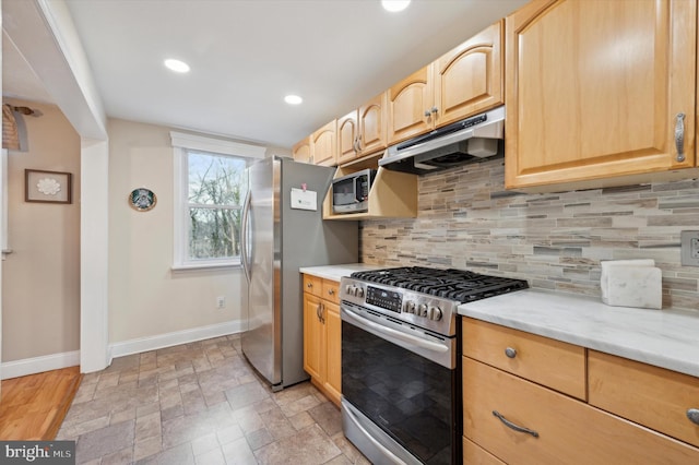 kitchen featuring light stone counters, decorative backsplash, light brown cabinets, and appliances with stainless steel finishes