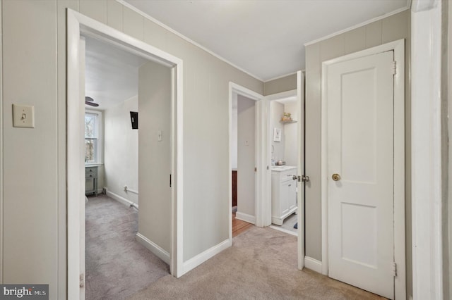 corridor featuring ornamental molding and light carpet