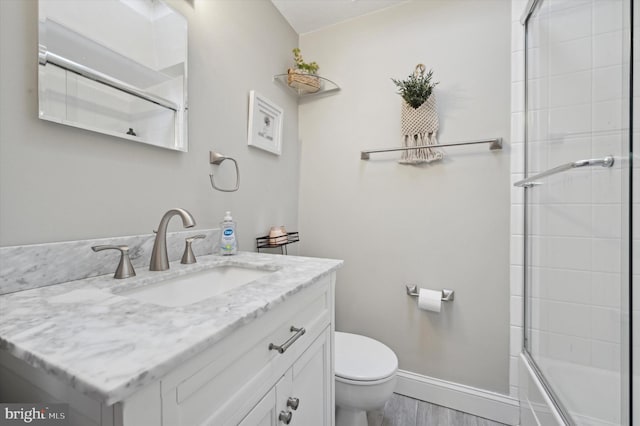 full bathroom featuring bath / shower combo with glass door, vanity, toilet, and hardwood / wood-style floors