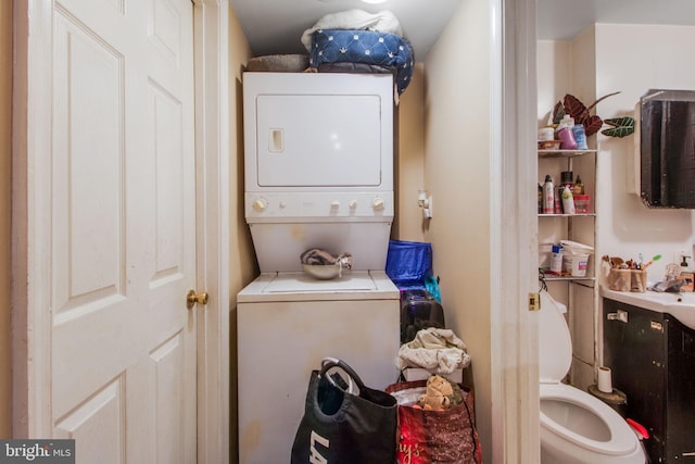 clothes washing area featuring stacked washer and clothes dryer