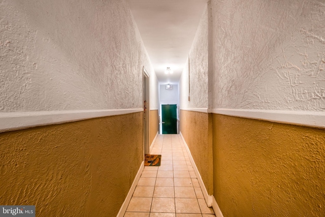 hall with tile patterned floors