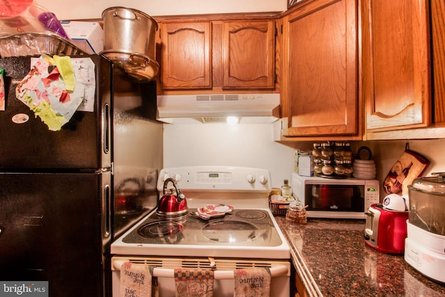 kitchen with white appliances and dark stone counters