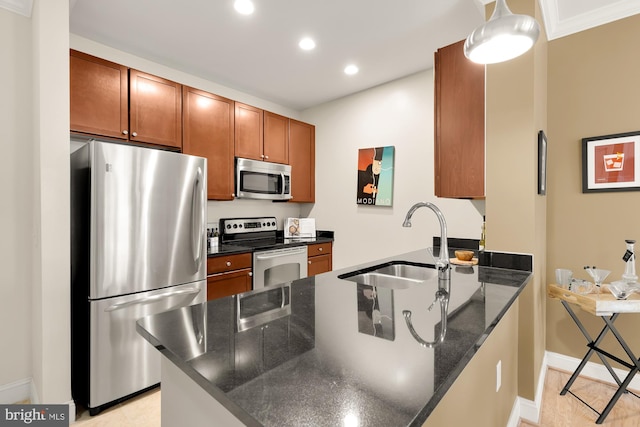 kitchen with pendant lighting, sink, stainless steel appliances, kitchen peninsula, and dark stone counters