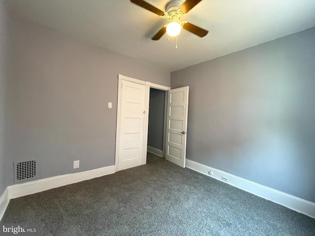 unfurnished bedroom with ceiling fan and dark colored carpet