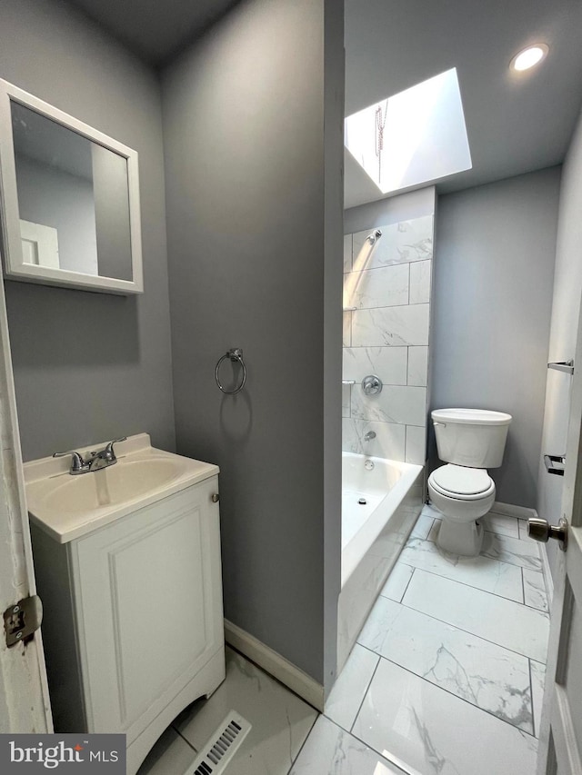 full bathroom with tiled shower / bath combo, vanity, toilet, and a skylight